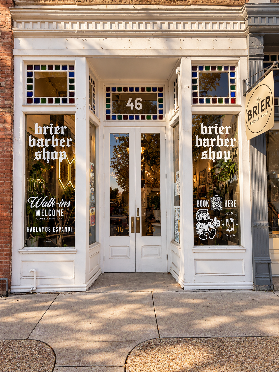 White Brier Barbershop storefront with double doors, stained glass trim, and the number 46 above the entrance